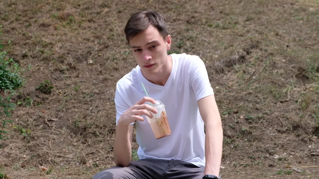Man putting a milkshake cup on the bench