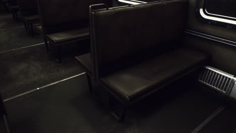 empty subway car interior reveals worn seats and dim lighting in urban setting