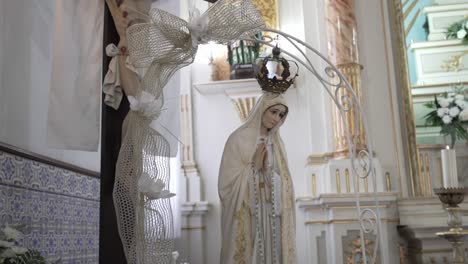 statue of the virgin mary with crown in a decorated church interior setting