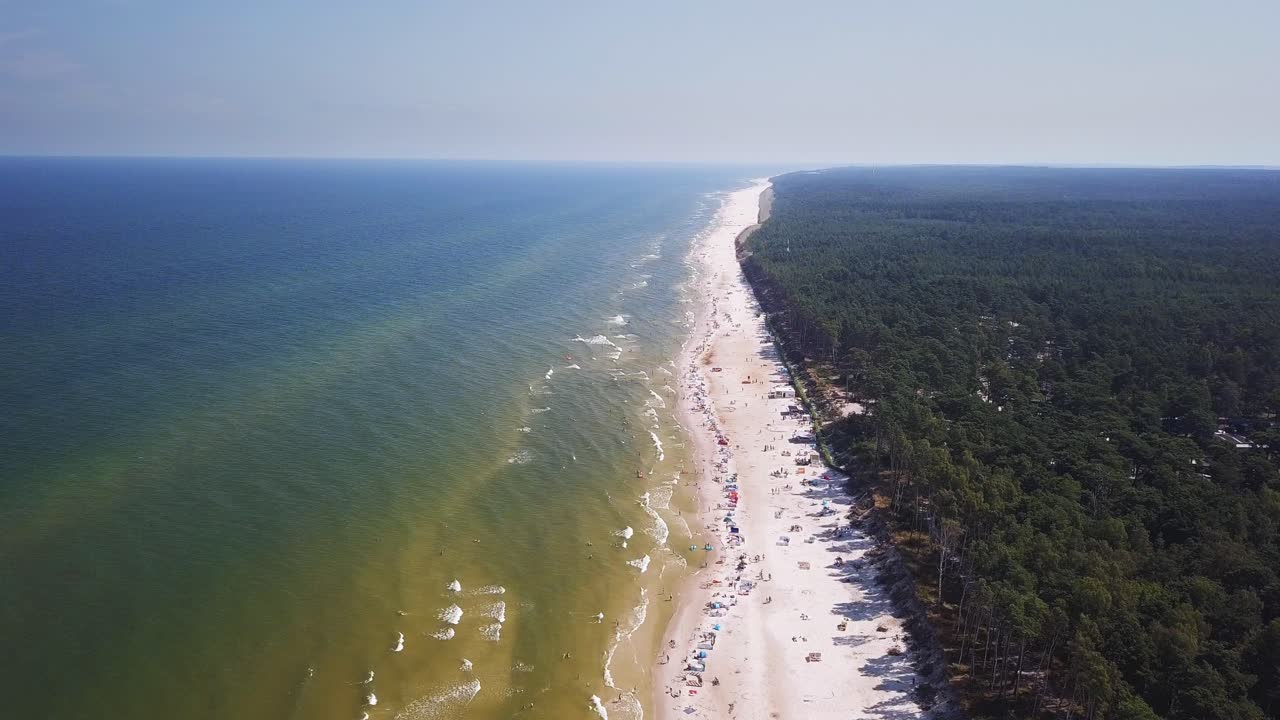 Nagranie z drona piaszczystej plaży, słoneczny letni dzień, Morze Bałtyckie, Polska, Lubiatowo