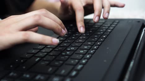 fingers of a young girl typing on a keyboard