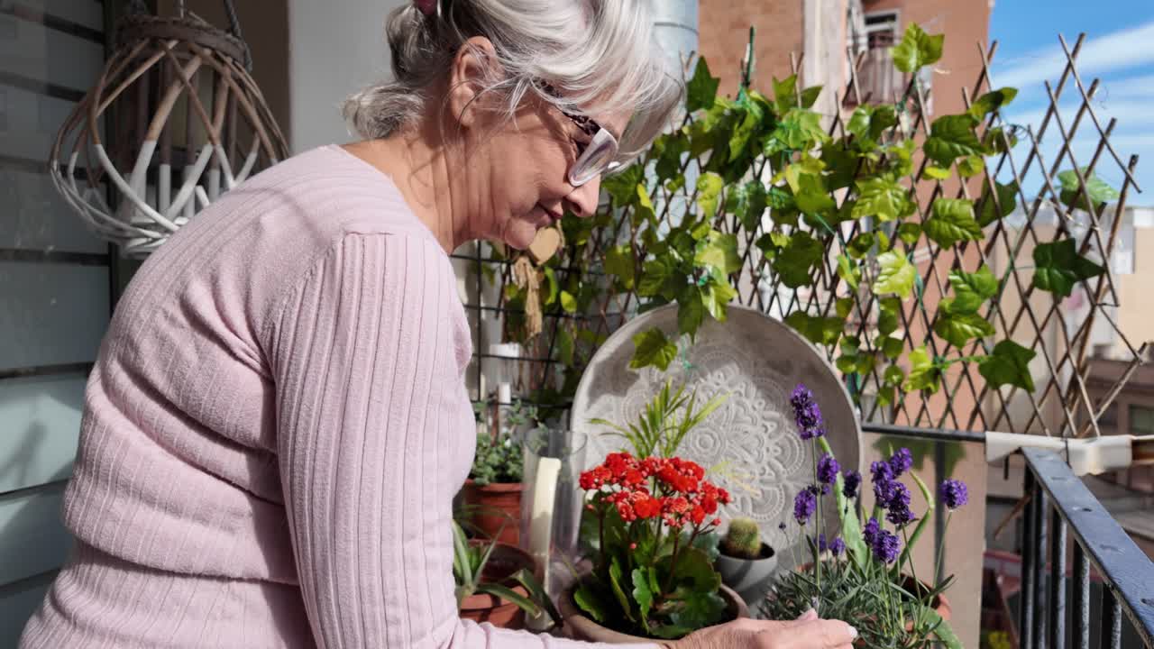 Senior woman tending to her plants on the balcony