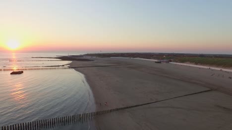 aerial: the pier, beach and lighthouse during sunset near the village westkapelle, the netherlands