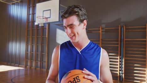 Porträt-Eines-Kaukasischen-Männlichen-Basketballspielers,-Der-Den-Ball-Hält-Und-Lächelt