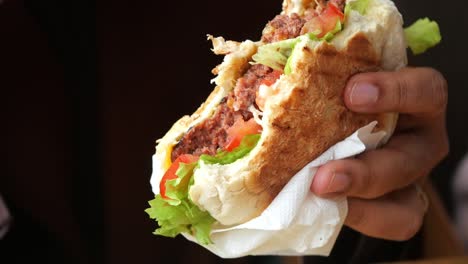 a person holding a delicious beef burger