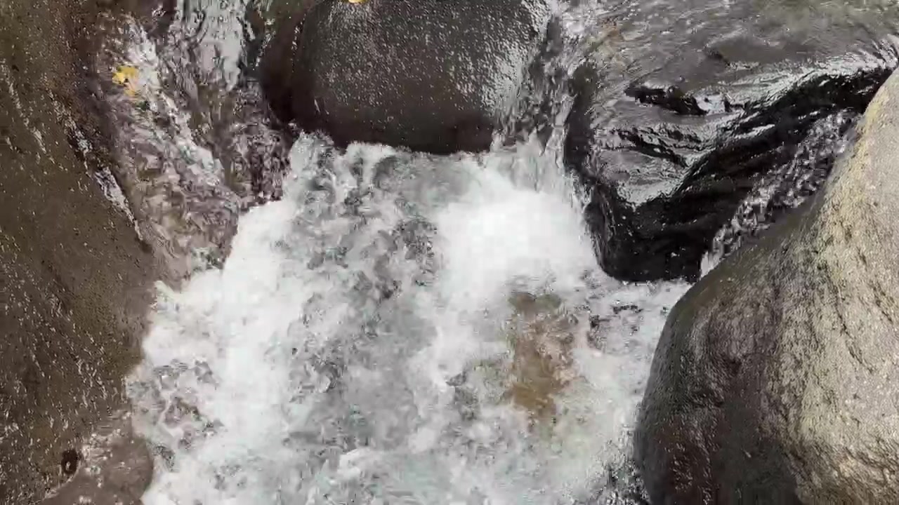 Acqua limpida che scorre sopra rocce scure del fiume