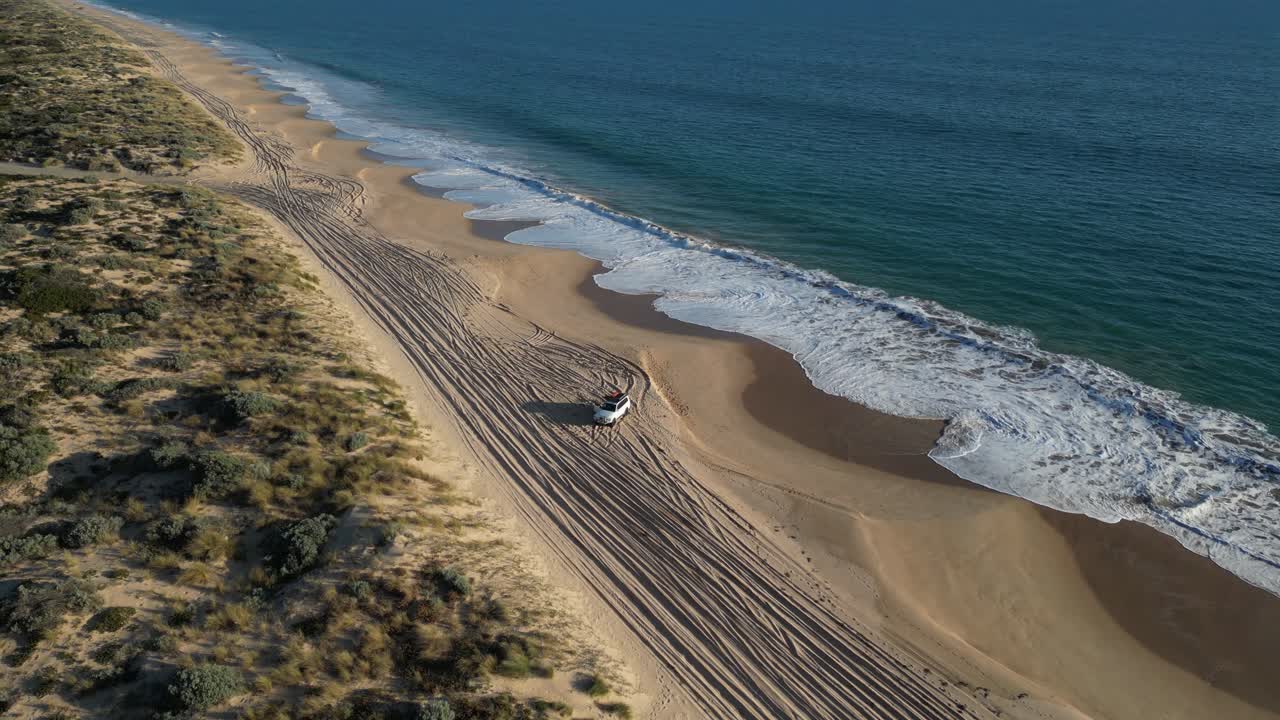 con estacionamiento de vehículos turísticos en la playa de arena de preston en la hora dorada