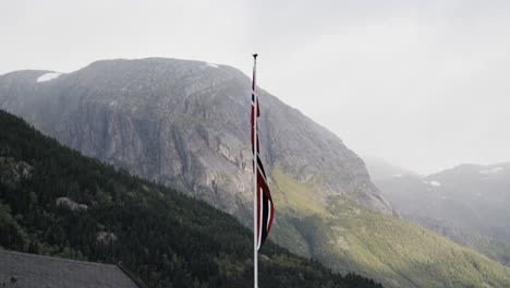 slim norwegian flag waving in slow motion with maountains in background