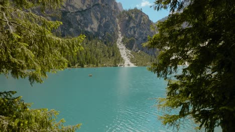 toma aérea de un dron que atraviesa el bosque hasta el río, lago di braies, italia, dolomitas