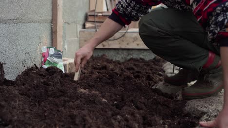 unrecognizable guy preparing clay soil in diy greenhouse