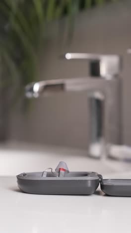 adult man taking hearing aids from the bathroom