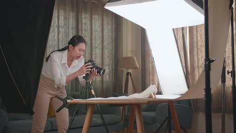 asian female photographer thinking then raising her index finger while taking photos of them in home studio