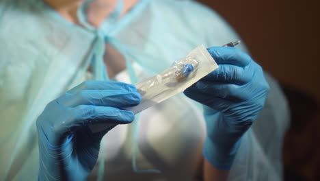 doctor hands in gloves filling syringe with injection liquid , vaccine