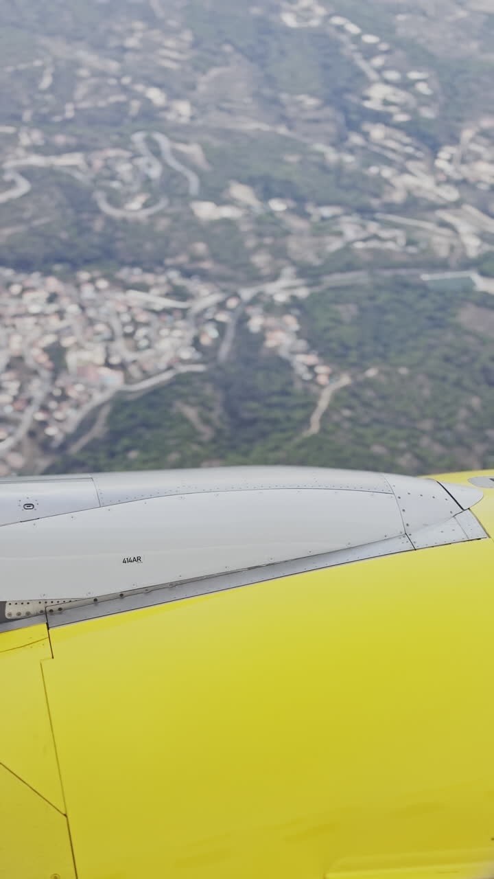 udsigt fra et flyvindue af himlen med flyets vinge i billedet i vertikalt format