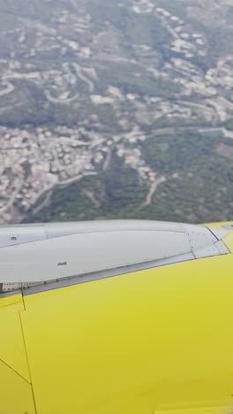 view from a plane window of the sky with the wing of the plane in shot in vertical