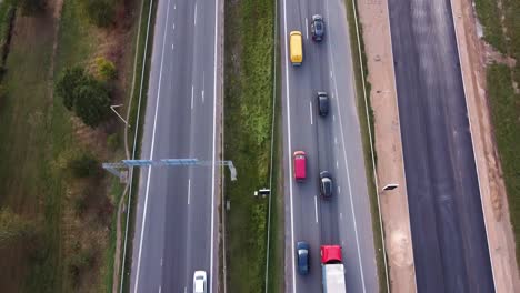 Direkt-über-Der-Aufnahme-Der-Autobahn-A1-In-Der-Stadt-Kaunas,-Während-Die-Drohne-Vorwärts-Fliegt-Und-Eine-Mehrstöckige-Kreuzung-Enthüllt