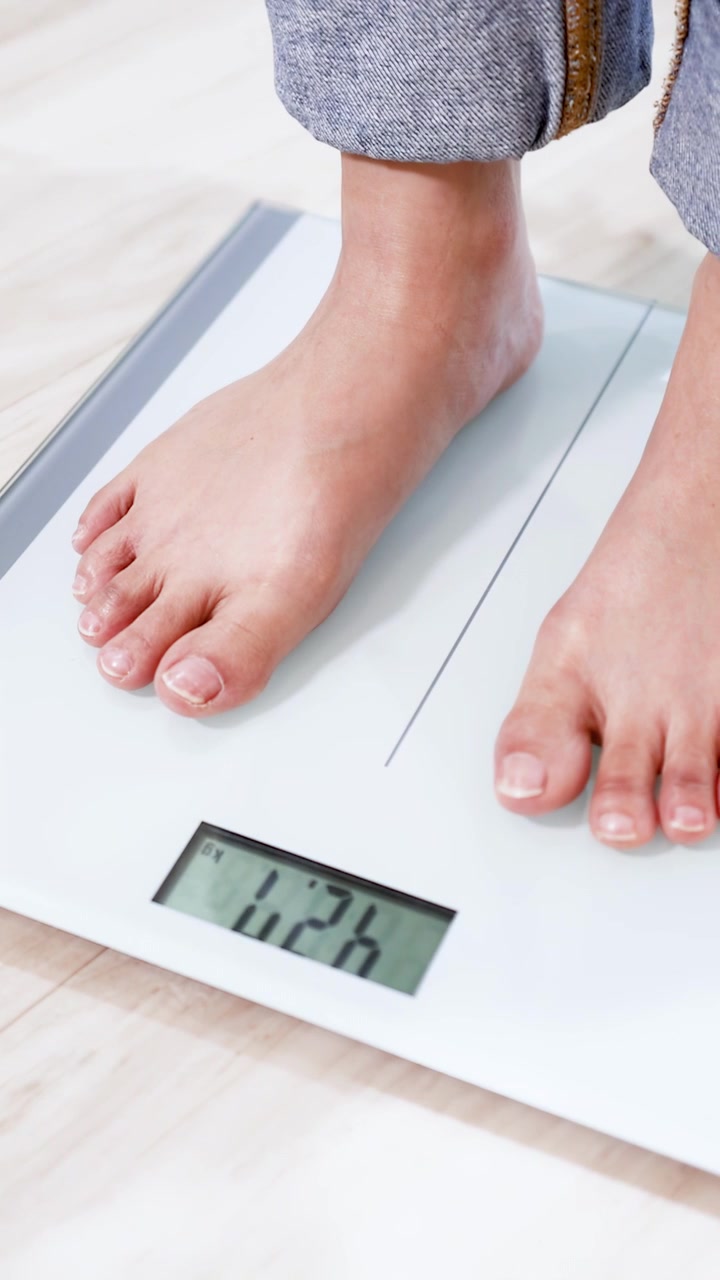 Person Stepping onto Digital Bathroom Scale to Check Weight