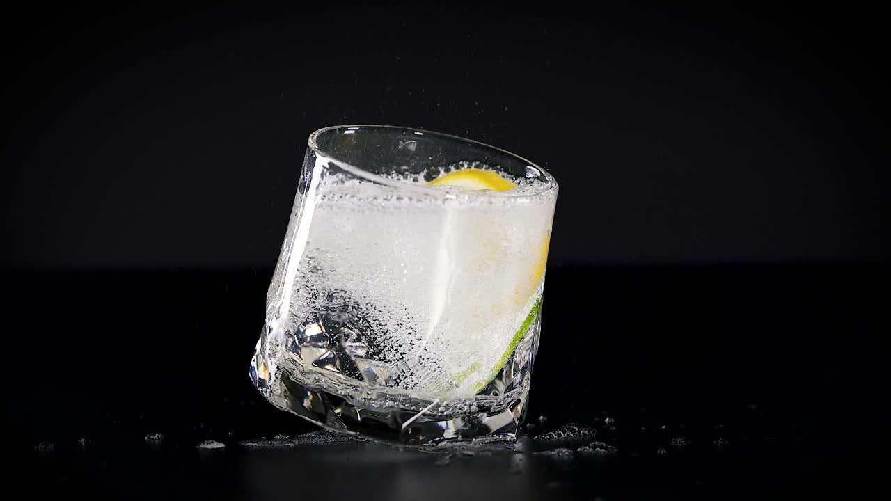 el vaso gira con rodajas de limón y cubitos de hielo.