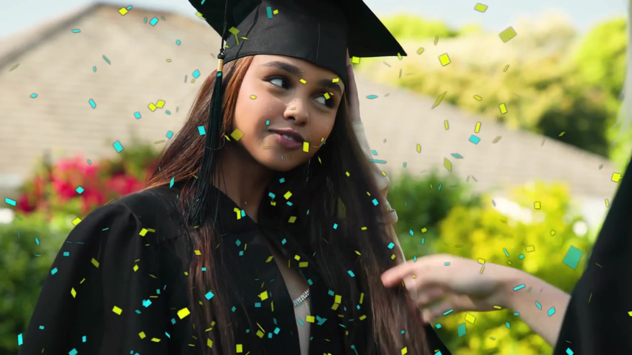 Donna laureata a cui un'amica sistema la toga, la telecamera si avvicina, coriandoli che celebrano la laurea.