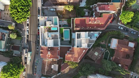 A direct top-down drone shot shows a modern white residential complex with a central swimming pool in Limonar, Spain. The clean, geometric design is perfect for themes of real estate and urban life