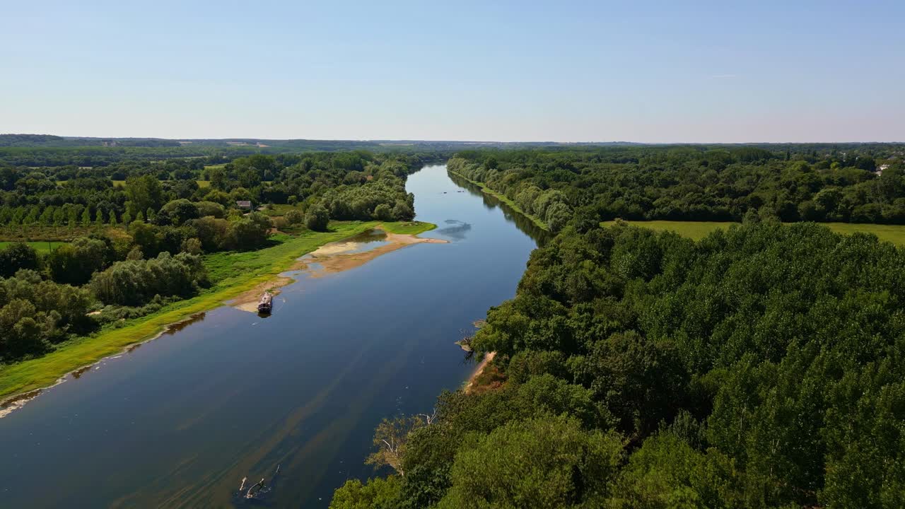 Amazing drone perspective view of Vienne River flowing through dense green forest near Chinon, Indre-et-Loire, France