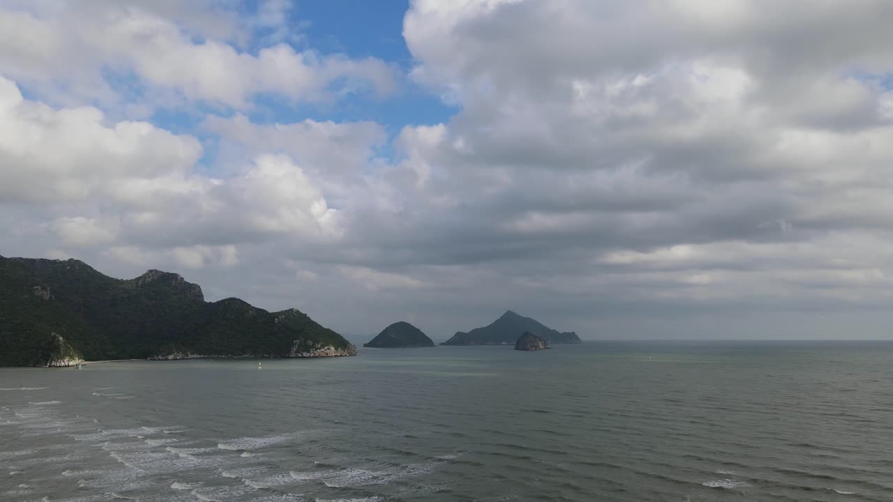 거친 바다, 해안으로 밀려오는 파도, 짙은 회색 구름과 푸른 하늘, 아름다운 풍경을 향한 항공 영상