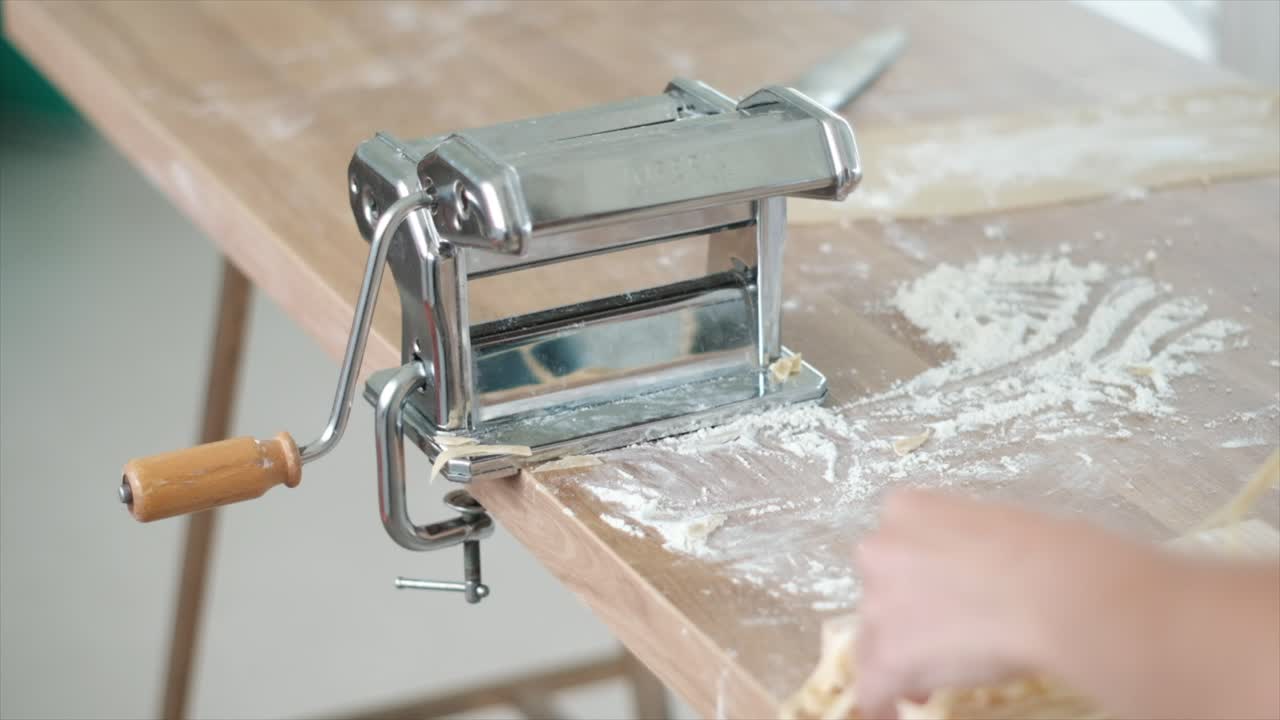 persona que hace pasta casera fresca con una máquina tradicional para hacer pasta en cámara lenta