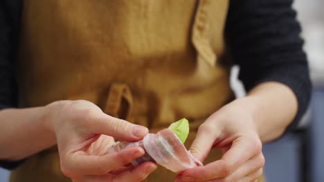 ama de casa de cultivo envolviendo aguacate en tocino