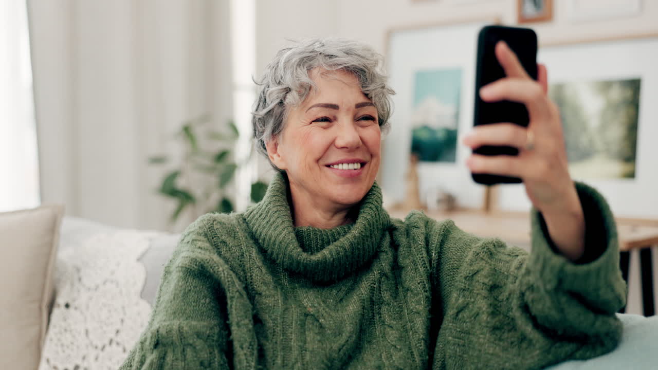 teléfono, videollamada y saludo con una anciana en el sofá