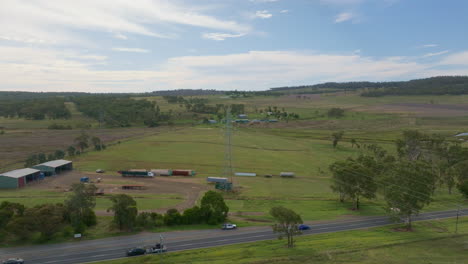 Granja-Australiana-De-Sobrevuelo-De-Drones-Aéreos-Con-Líneas-Eléctricas-De-Alto-Voltaje-Y-Carretera-Rural,-4k