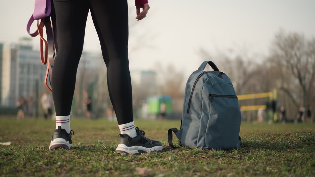 Girl Walking City, Young Lady Strolling Through Urban Area, Woman With Handles On Backpack Crossing Park Area Busily, Young Woman Briskly Walking With Backpack By Her Side In City Park Setting