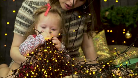 niña jugando con luces de navidad
