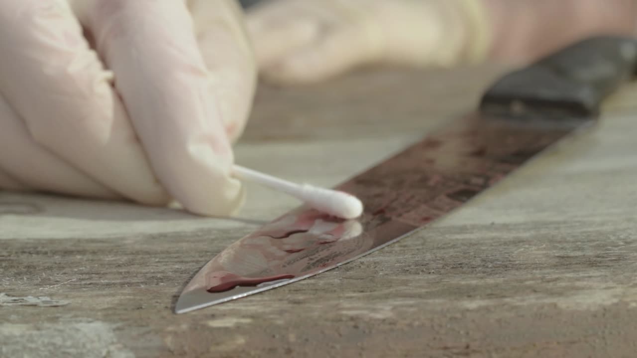 un científico forense recoge pruebas de muestras de sangre en el primer plano de la escena del crimen.
