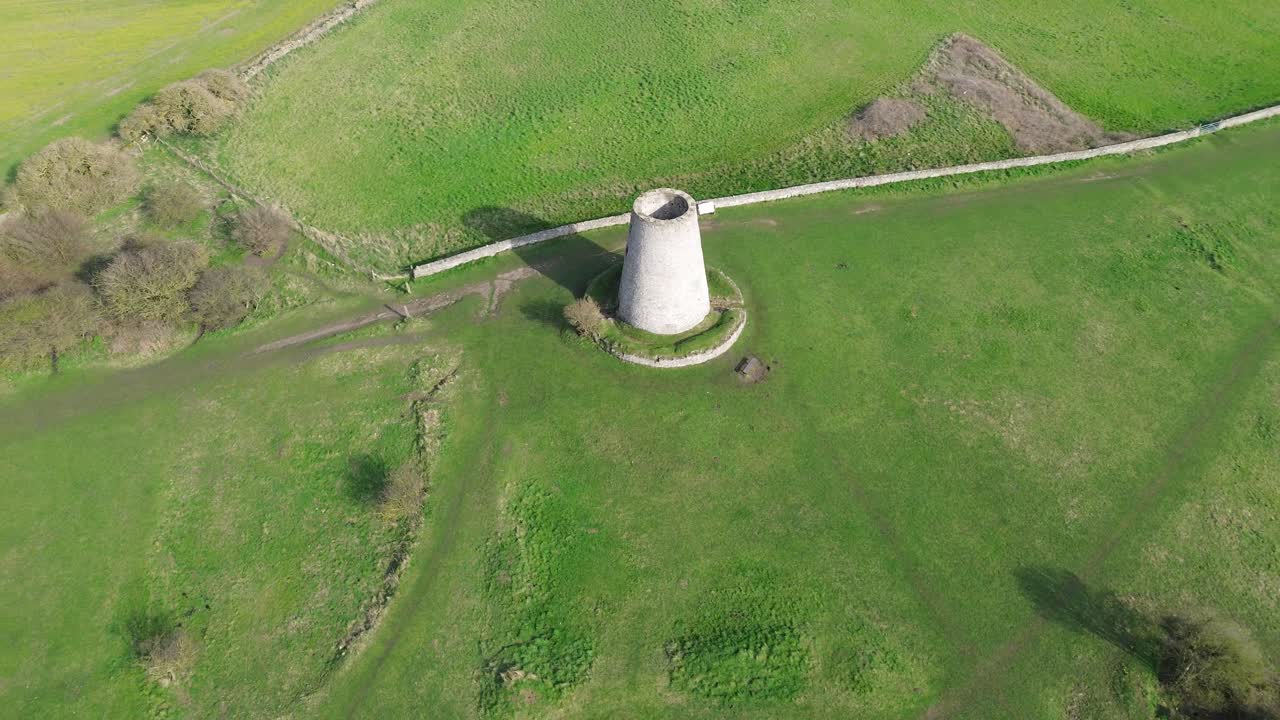 Orbit drone Cleadon Windmill di Cleadon, South Tyneside, Inggris. Rotasi udara gaya 4K di sekitar kincir angin menara batu bersejarah di tengah ladang dan jalan pedesaan hijau