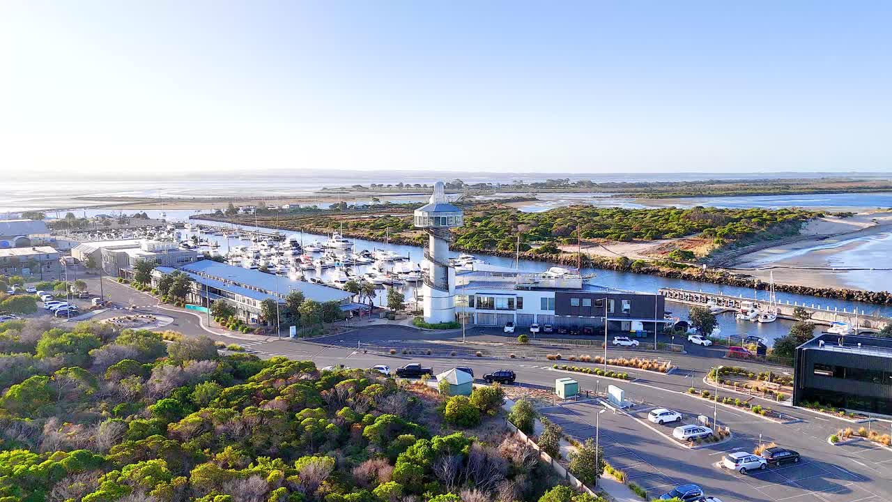 Aerial footage of Queenscliff Marina in Bellarine, Victoria, showcasing boats, lighthouses, and coastal scenery under clear skies