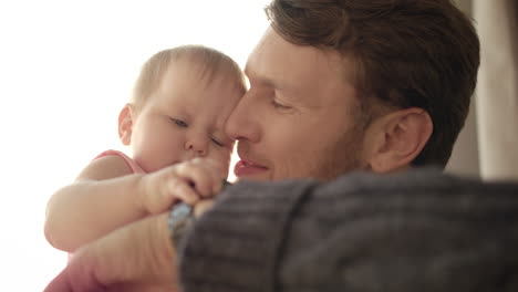 Bärtiger-Vater-Küsst-Baby.-Vaterzeitkonzept.-Baby-Berührende-Armbanduhr