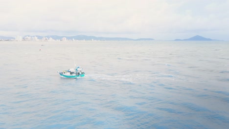 following from side view a tradicional wooden fisher boat in the ocean