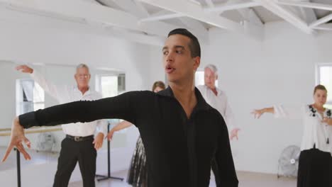 mixed-race-male-dance-teacher-taking-a-ballroom-dancing-class-at-a-dance-studio