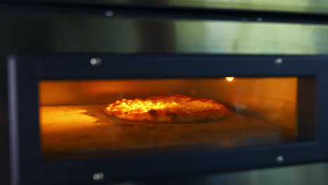 delicious pizza in hot oven. chef is taking ready bakery with a special pizza spatula. process of baking pizza in pizzeria.