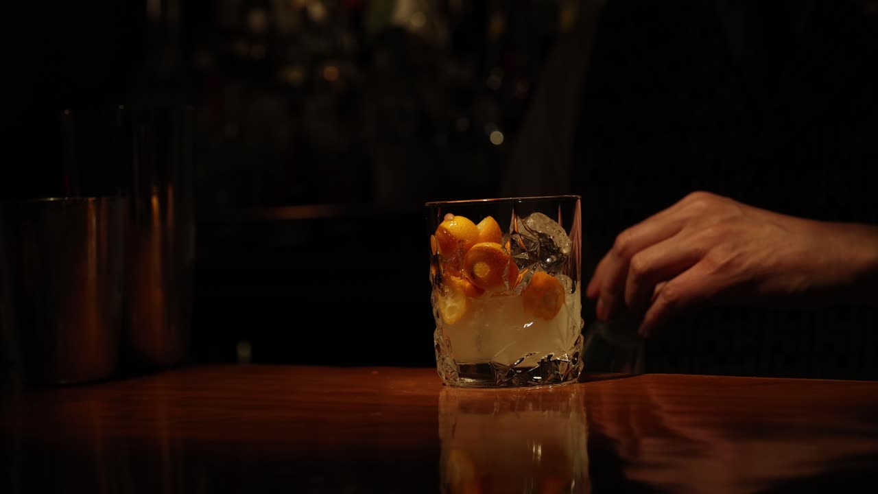 Barman che prepara un cocktail agli agrumi in un bar