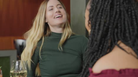 foto por cima do ombro de duas mulheres conversando e rindo durante o encontro