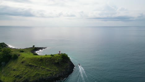 Aerial-view-of-a-boats-passing-the-Farol-da-Lagoa-Azul,-in-Sao-Tome,-Africa