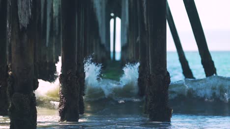 slow motion shot of waves breaking and splashing on old wooden pier