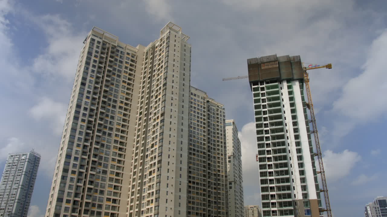 Construction building timelapse with moving crane and fast moving layered clouds