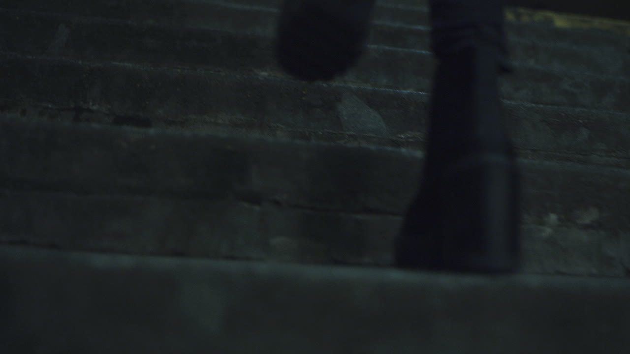 zapatos femeninos caminando por las escaleras solos por la noche luces de la ciudad en el edificio.