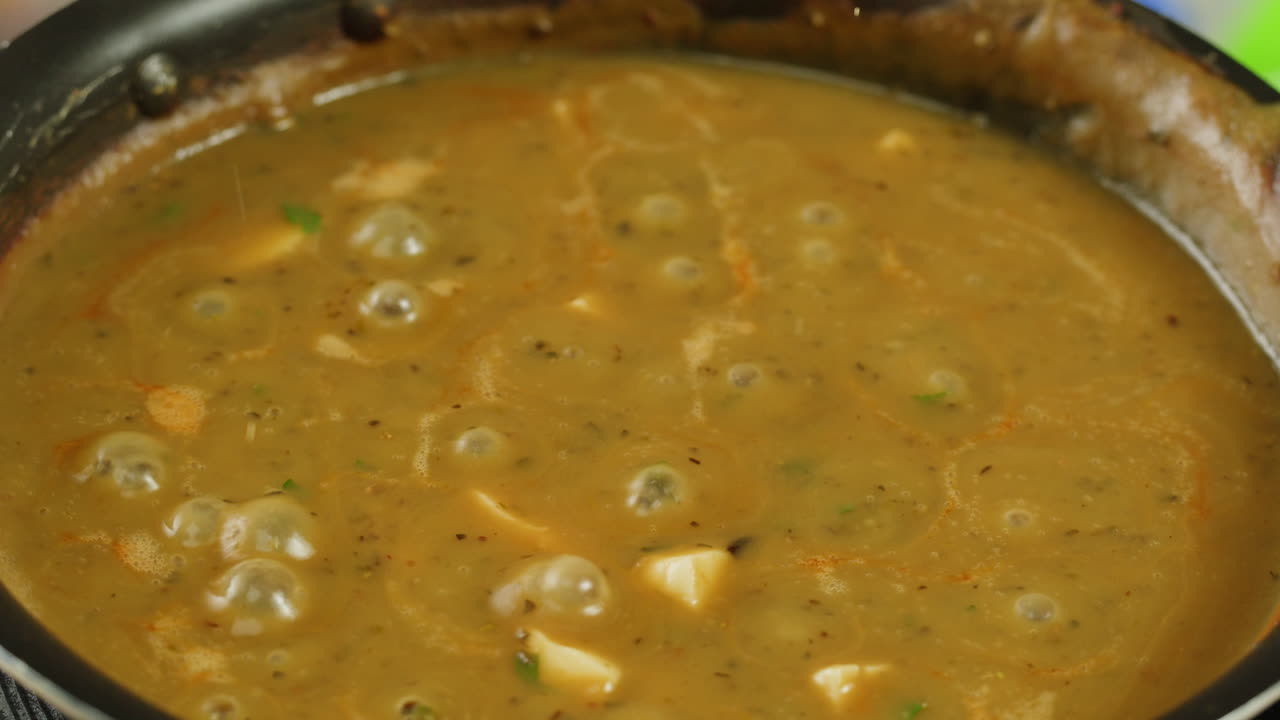 Cooking traditional Indian meal Palak Panir with spinach and cheese close up. Palak paneer is an Indian dish, consisting of paneer in a thick paste made from pureed spinach, Palak paneer is prepared by first boiling and pureeing spinach.