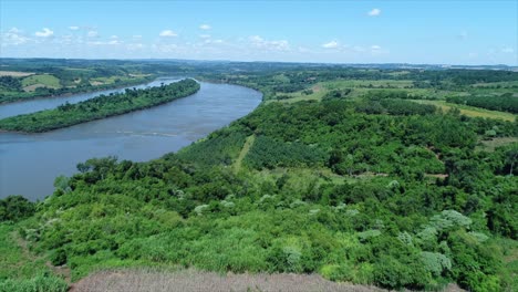 Vista-Aérea-Del-Río-Uruguay,-Que-Marca-La-Frontera-Natural-Entre-Argentina-Y-Brasil,-Mostrando-El-Majestuoso-Caudal-Del-Río-Y-Los-Paisajes-Circundantes.