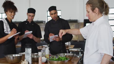 Caucasian-female-chef-teaching-diverse-group