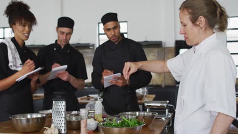 cocinera caucásica que enseña a un grupo diverso