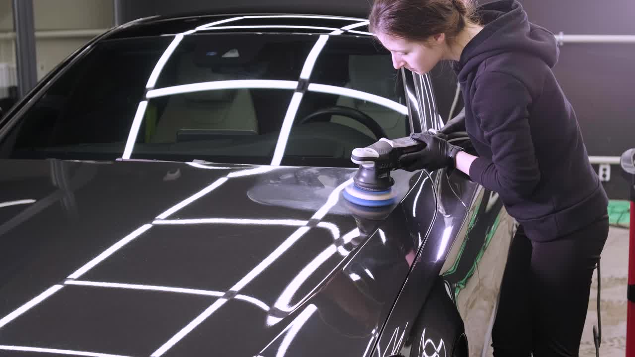 페인트 복원을 위해 기계와 폴리셔를 사용하는 전문 자동차 디테일링.